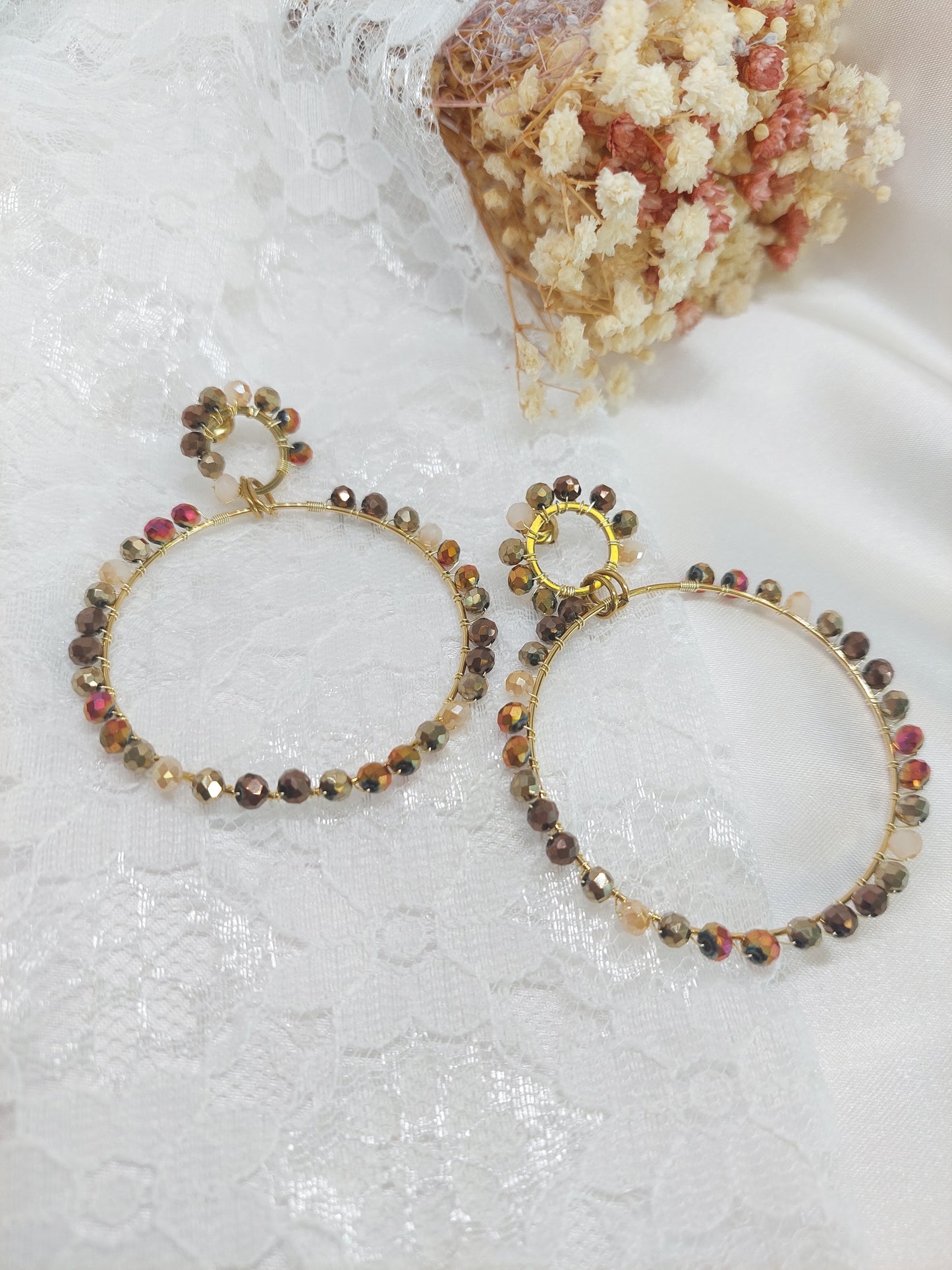 Boucles d'oreilles créoles en acier inoxydable et perles de verre dans les teintes de beige et marron. constitué de 2 anneaux, un petit et l'autre suspendus plus grand