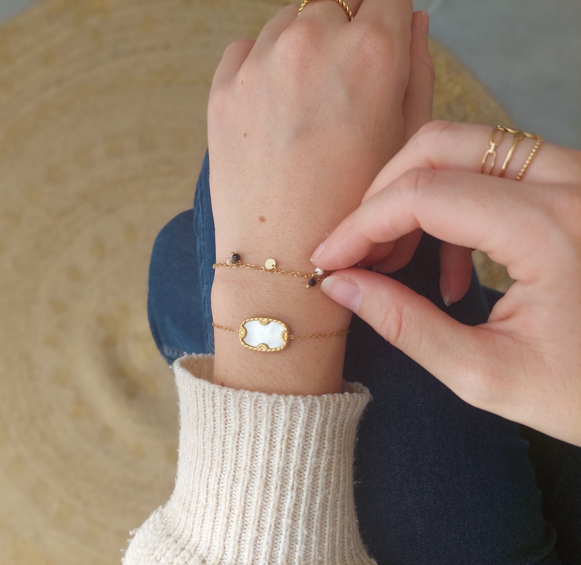 bracelet doré avec des petite pampilles et des petite perles blanche et noire