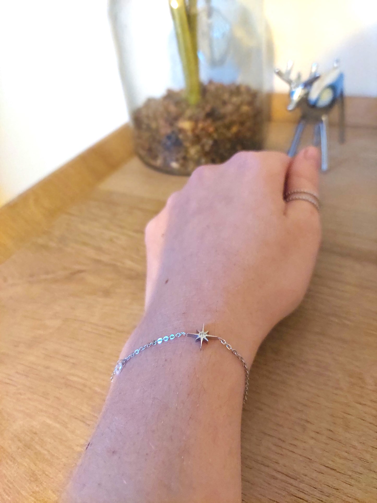 bracelet argenté avec une étoile et au centre un oxyde de zirconium et à côté une perle de Crystal 