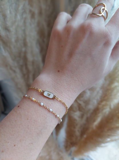 bracelet personnalisé avec une initial sur un fond blanc nacré