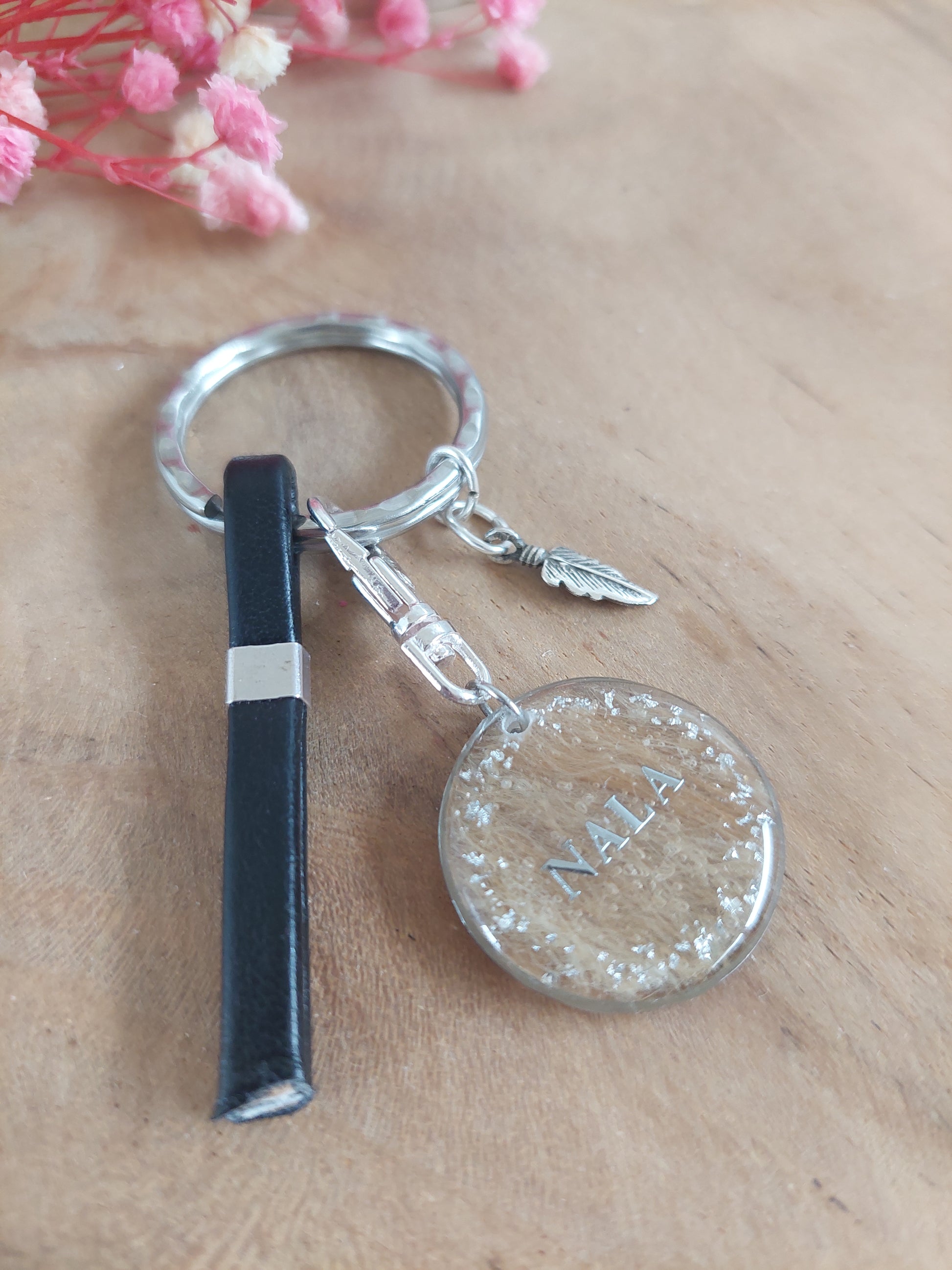 porte clé: bijou souvenir pet mémorial avec une plume en acier inoxydable et une lanière de cuire noir choix du charm modèle NOVA avec fond de l'insert en poils et prénom écrit au centre