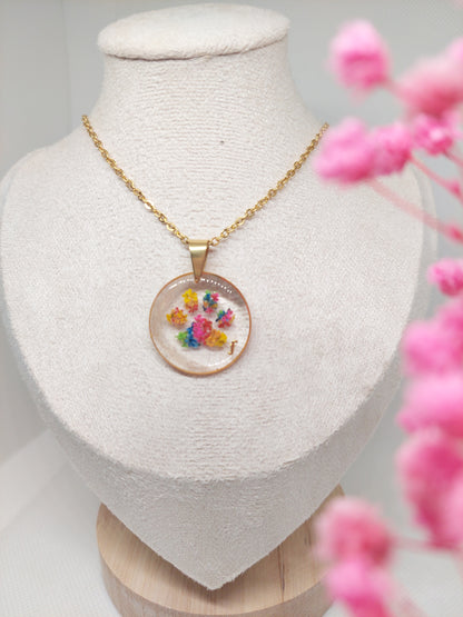 bijou souvenir collier doré avec une patte de chien ou chat en fleurs séchées avec un mèche de poils mis sur le coté du pendentif