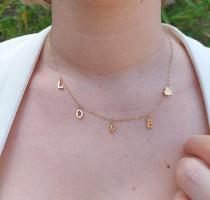 collier souvenir avec des lettres breloque formant le mot LOVE ainsi qu'un petit coeur en acier inoxydable