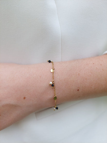 bracelet doré avec des petite pampilles et des petite perles blanche et noire