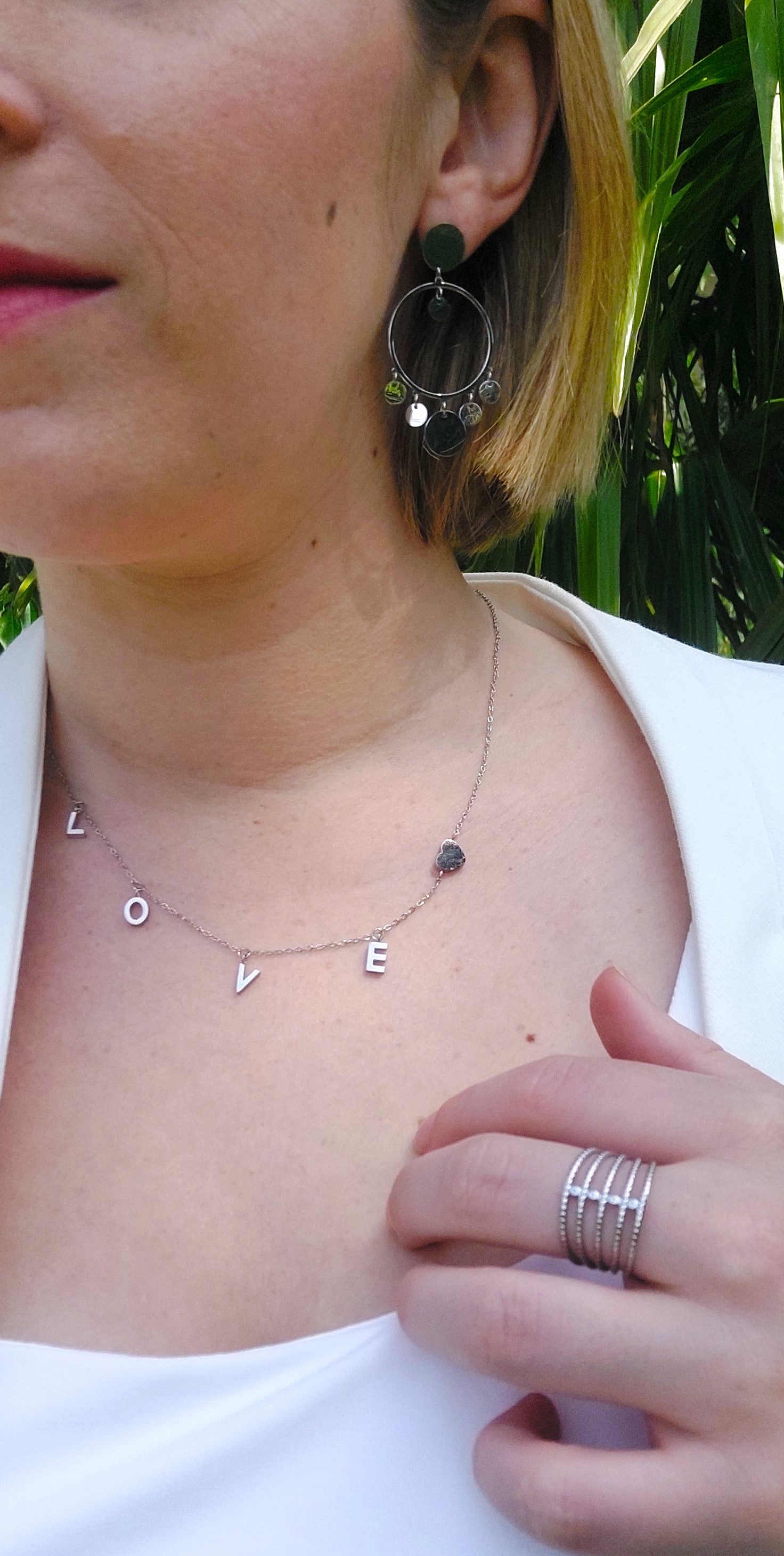 collier souvenir avec des lettres breloque formant le mot LOVE ainsi qu'un petit coeur en acier inoxydable