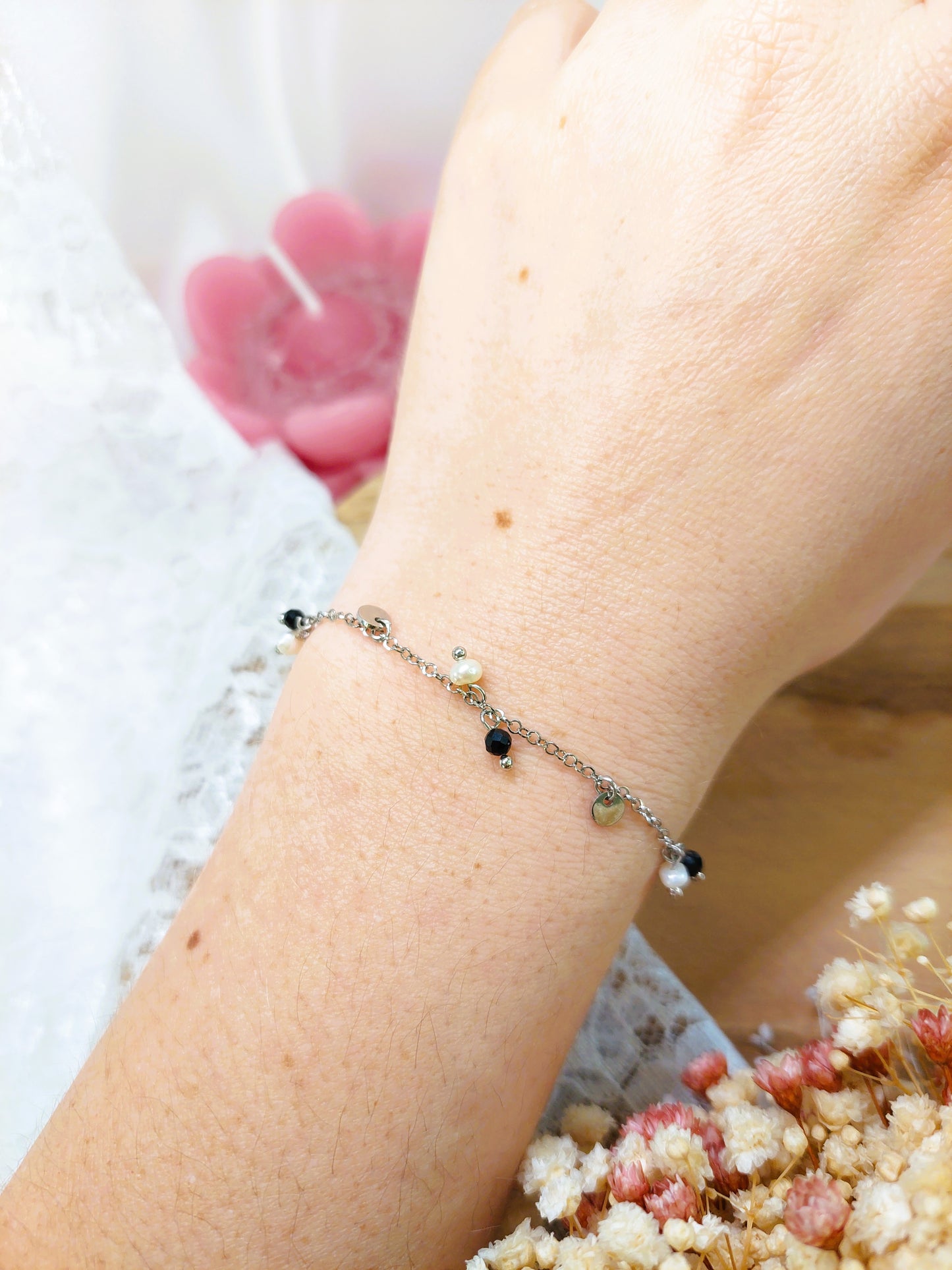 bracelet argenté avec des petite pampilles et des petite perles blanche et noire