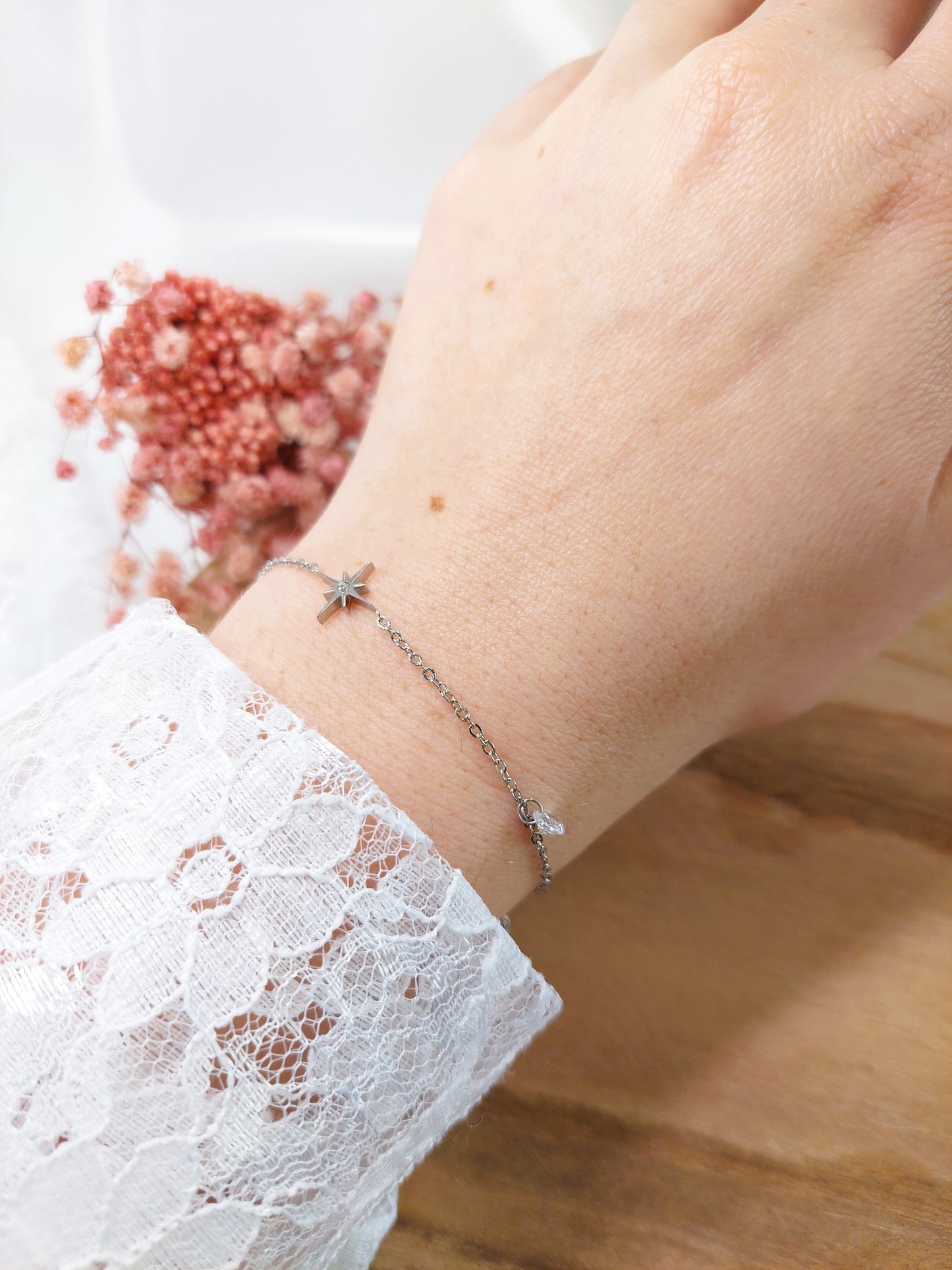 bracelet argenté avec une étoile et au centre un oxyde de zirconium et à côté une perle de Crystal 