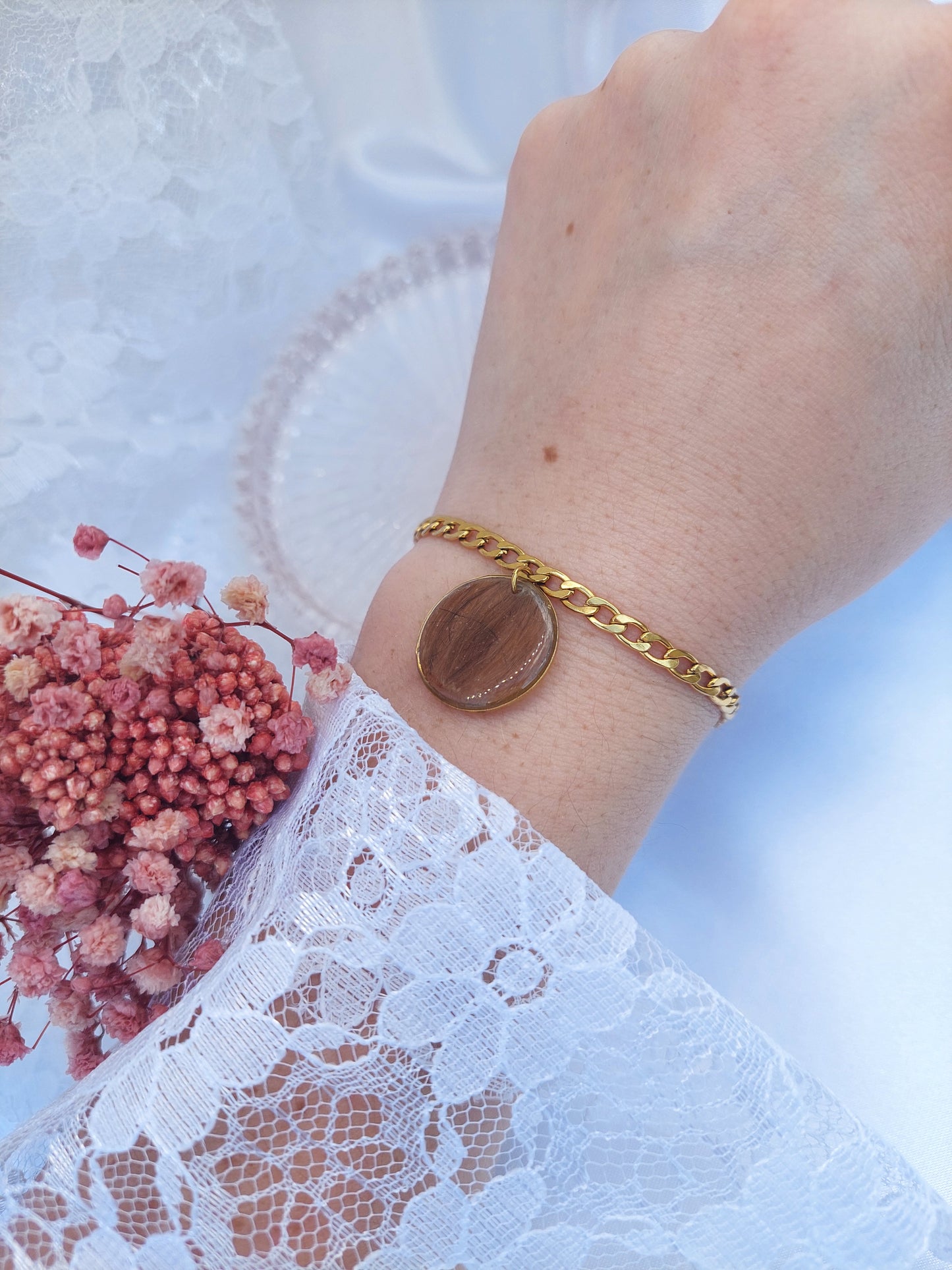 bijou souvenir: bracelet avec une chaine gourmette et un insert effet breloque de 2cm remplis d'une mèche de cheveux et une initiale au centre