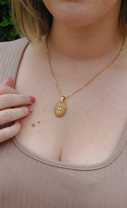 collier souvenir avec un pendentif ovale et une date à l'intérieur et des fleurs séchées