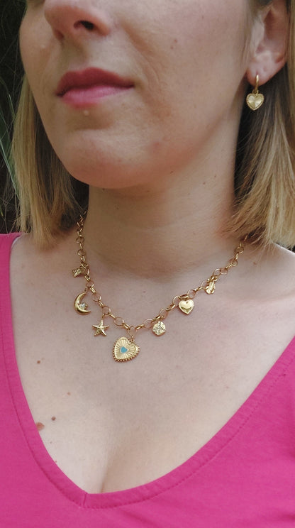 Collier en acier inoxydable doré avec une chaine grosse mailles et plusieurs breloque (coeur, étoile de mer, lune, abeille)