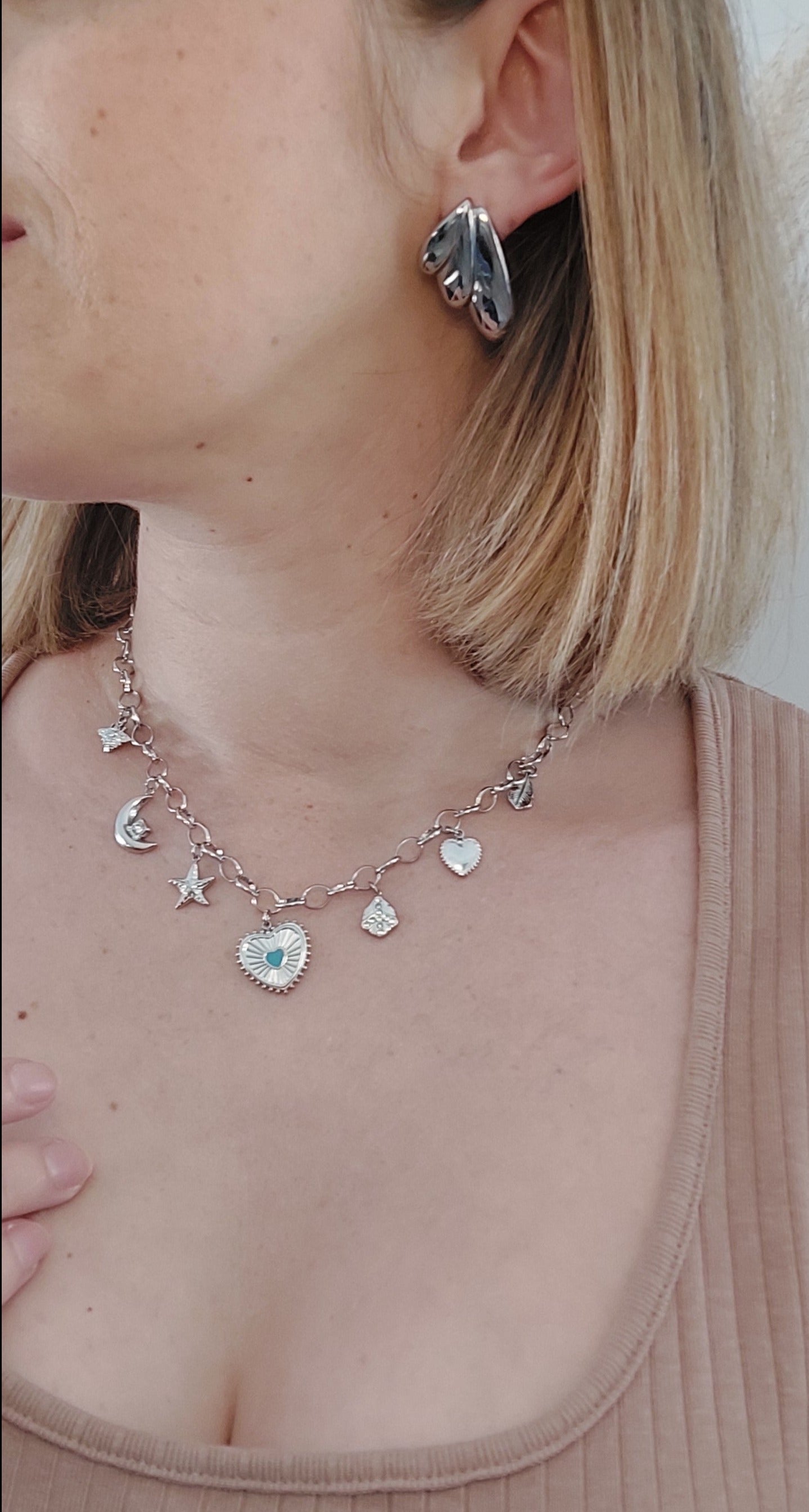 Collier en acier inoxydable argenté avec une chaine grosse mailles et plusieurs breloque (coeur, étoile de mer, lune, abeille)