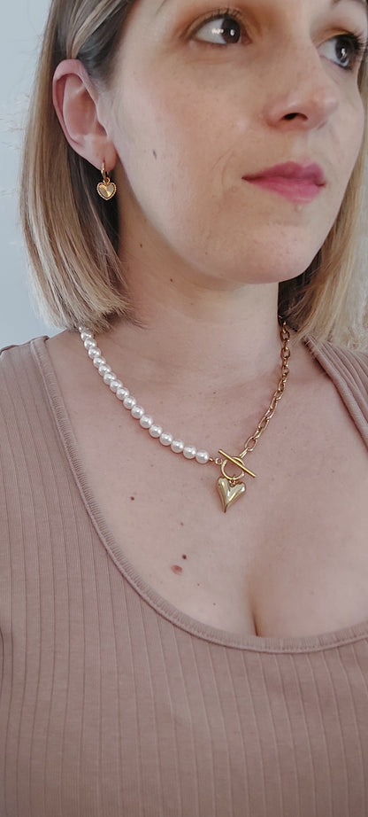 collier moitié en acier inoxydable doré avec grosse mailles et l'autre moitié en perle blanche. l'ouverture se fait sur le devant avec un pendentif en forme de coeur