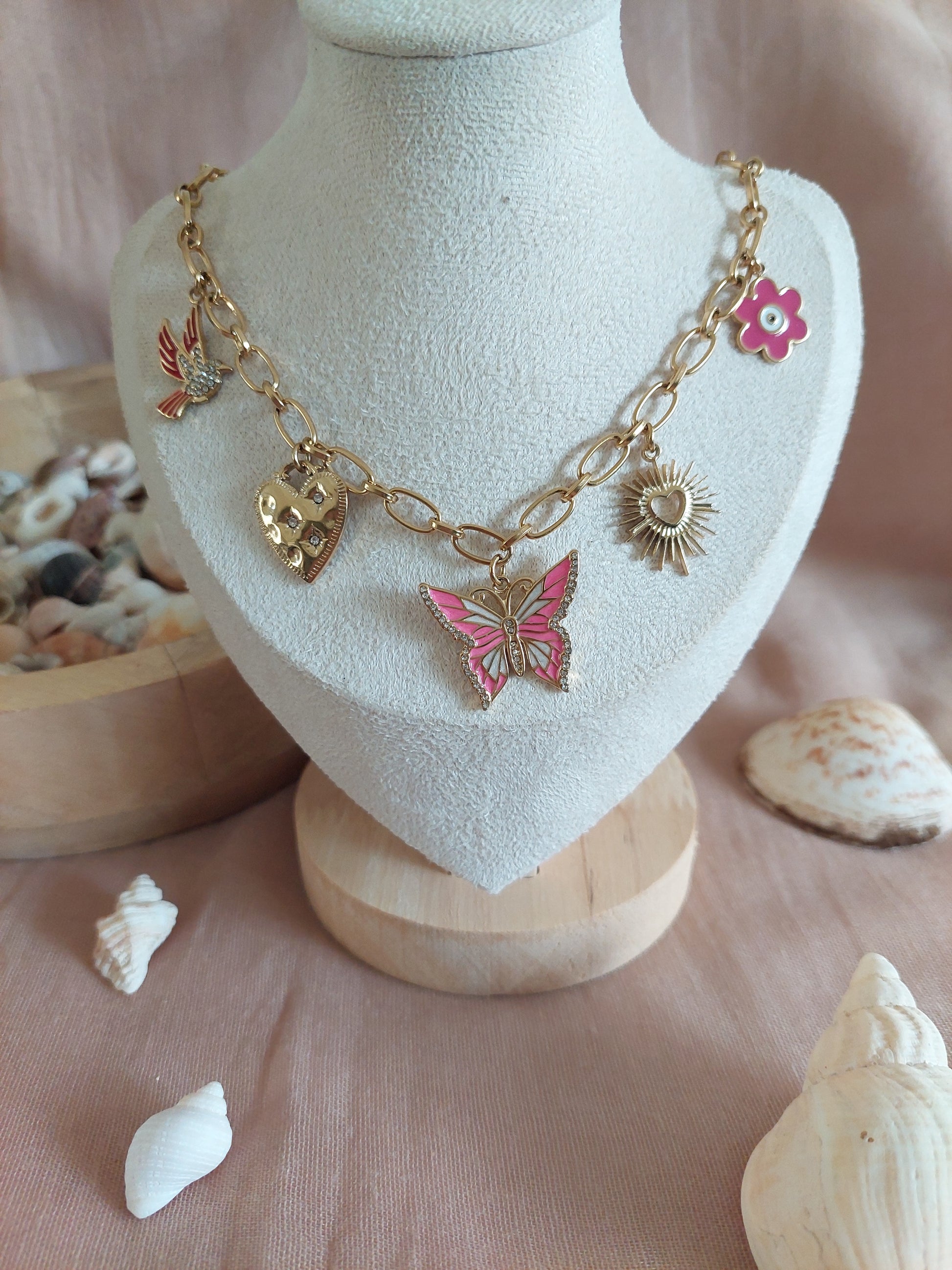 collier en acier inoxydable doré avec une chaine en grosse mailles et plusieurs charms (papillon, oiseau, fleur, coeur)