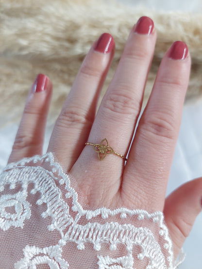 Bague en acier inoxydable doré avec un trèfle sur le dessus.