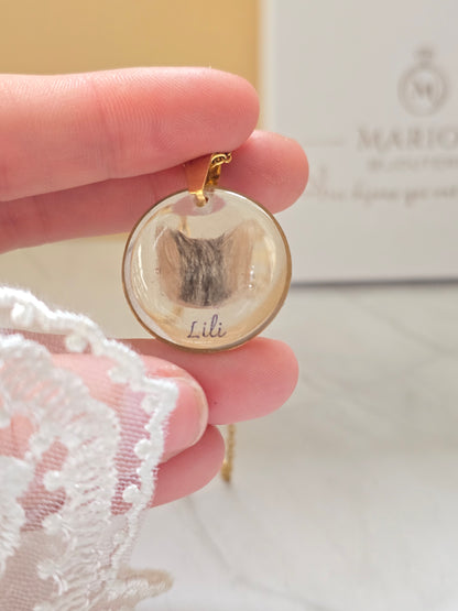 collier avec un pendentif rond et insertion de poils en forme de tête de chat