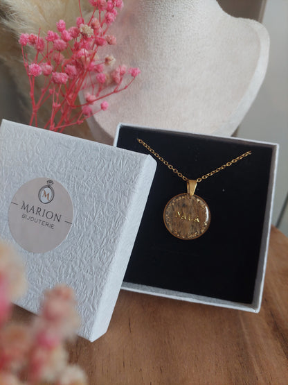 Collier souvenir pet mémorial avec un pendentif rond avec le fond en poils et un prénom au centre