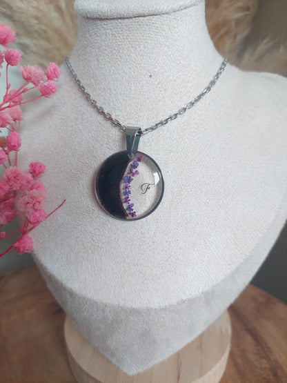 collier argenté pet mémorial avec une les poils d'un animal placé en forme de lune et des fleurs violettes et une initiale