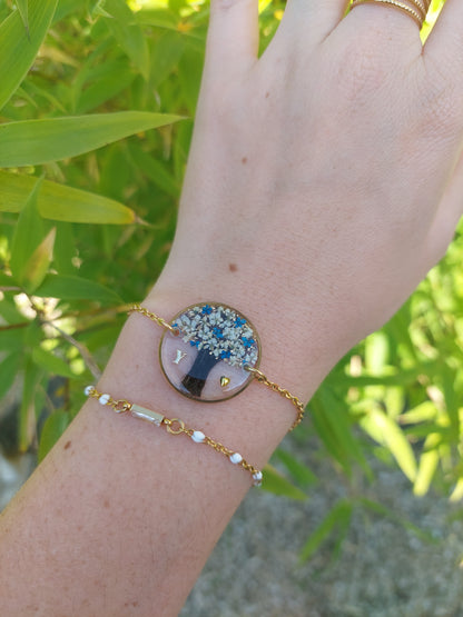 bracelet souvenir avec insertion de cheveux en forme d'arbre de vie et des fleurs bleu et blanche avec une initiale