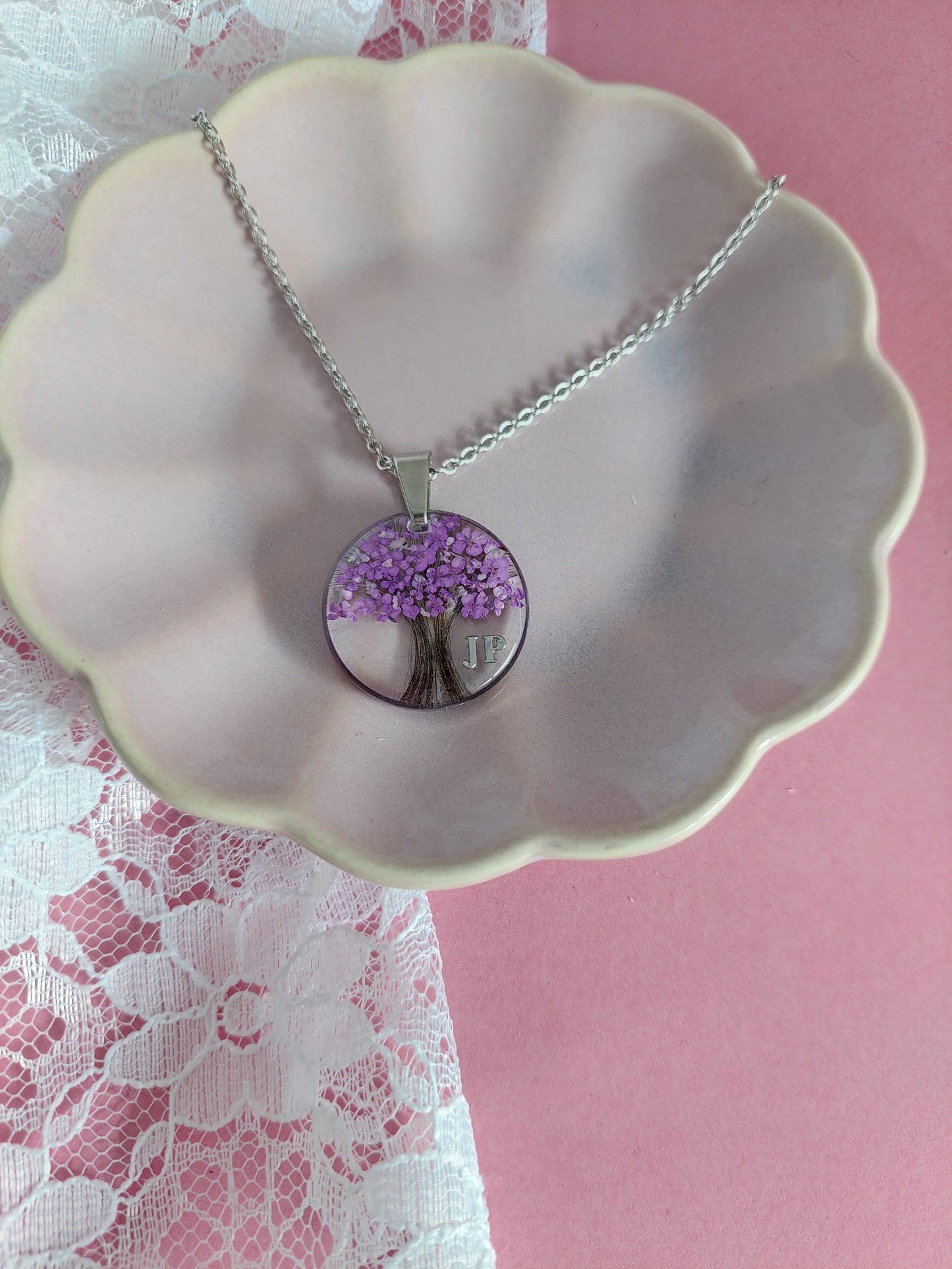 bijoux souvenir avec des poils placés en forme d'arbre de vie et des fleurs violettes et des feuilles d'argent