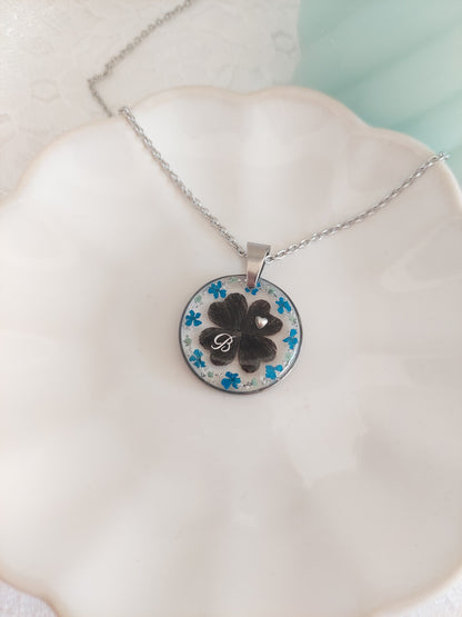 collier pet mémorial avec 4 petits coeur en poils placé pour former un trèfle à quatre feuilles. Avec des fleurs bleu et un initiale