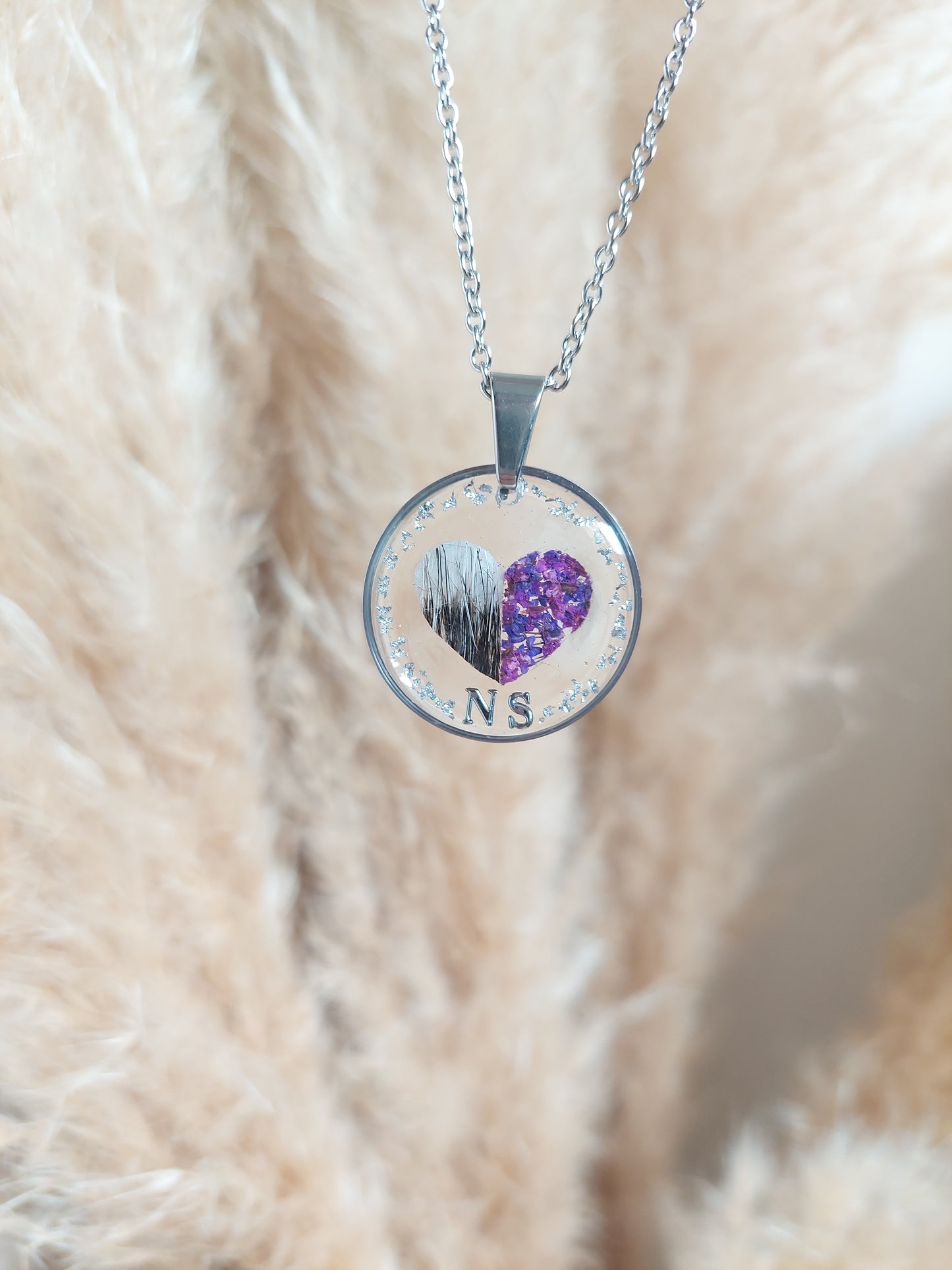 bijoux souvenirs: collier avec un coeur au centre réalisé avec une moitié en poils de chat et l'autre moitié en fleurs séchées violette