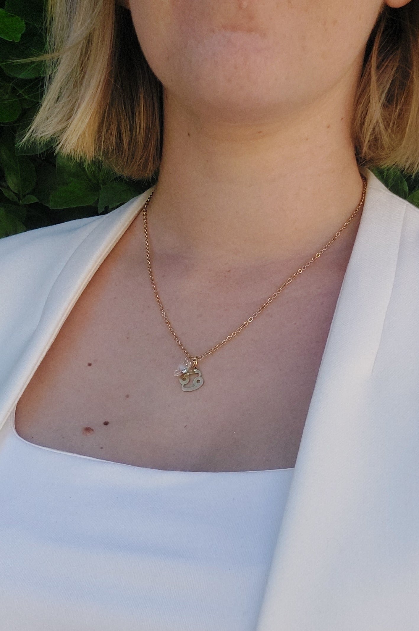 collier personnalisable en acier inoxydable doré avec deux pendentif, un signe du zodiaque Cancer et un coeur en cristal blanc