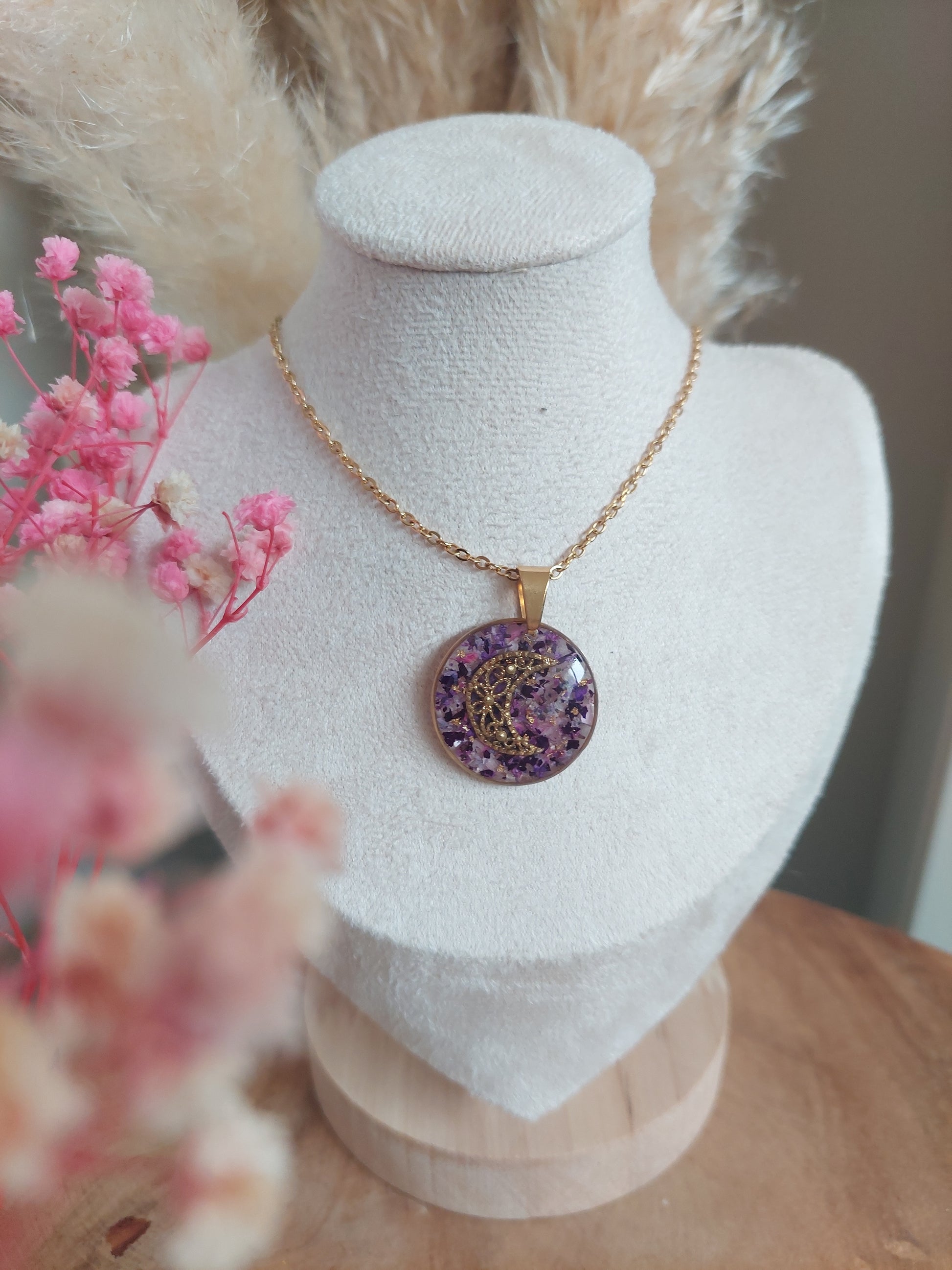 Collier souvenirs avec un pendentif rond avec des fleurs séchées violettes et roses