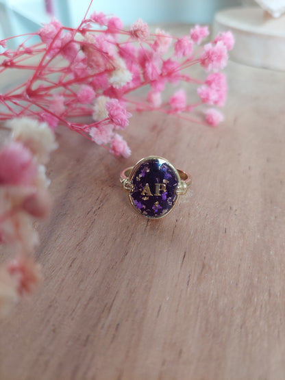 bijou souvenir: bague réglable en acier inoxydable et insertion de fleurs séchées violettes et deux initiales